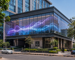 Transparent LED display screen integrated into a commercial building glass façade.