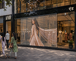 Transparent LED display screen installed on a retail storefront glass for promotional content.